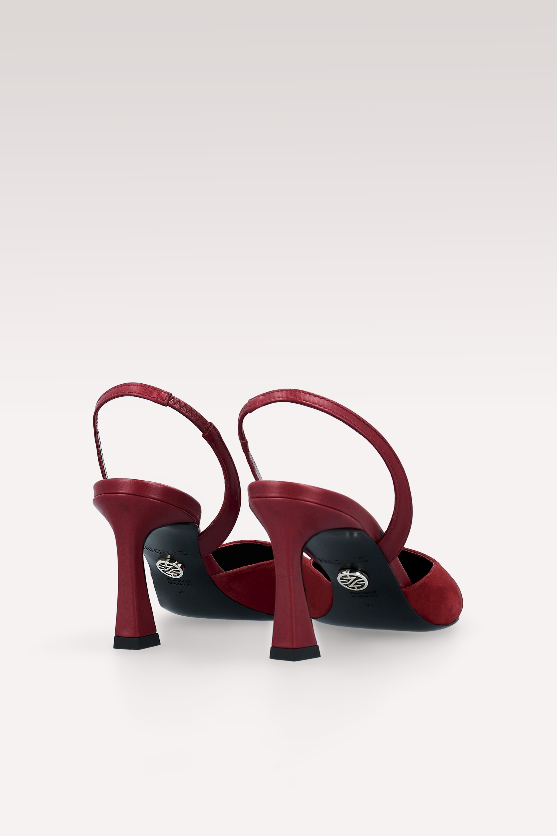 Red high-heeled shoes with black soles on a white background
