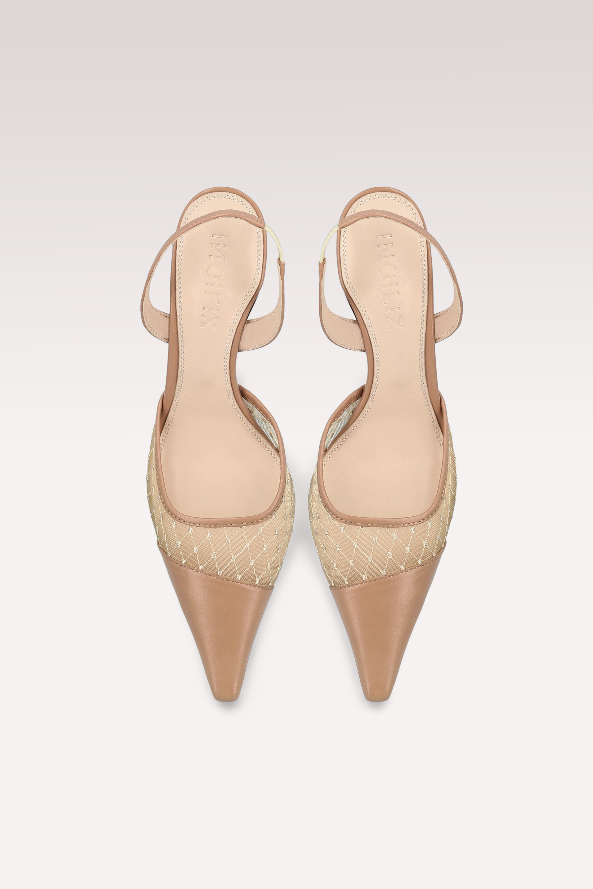 Pair of beige high-heeled shoes with pointed toes on a light gray background