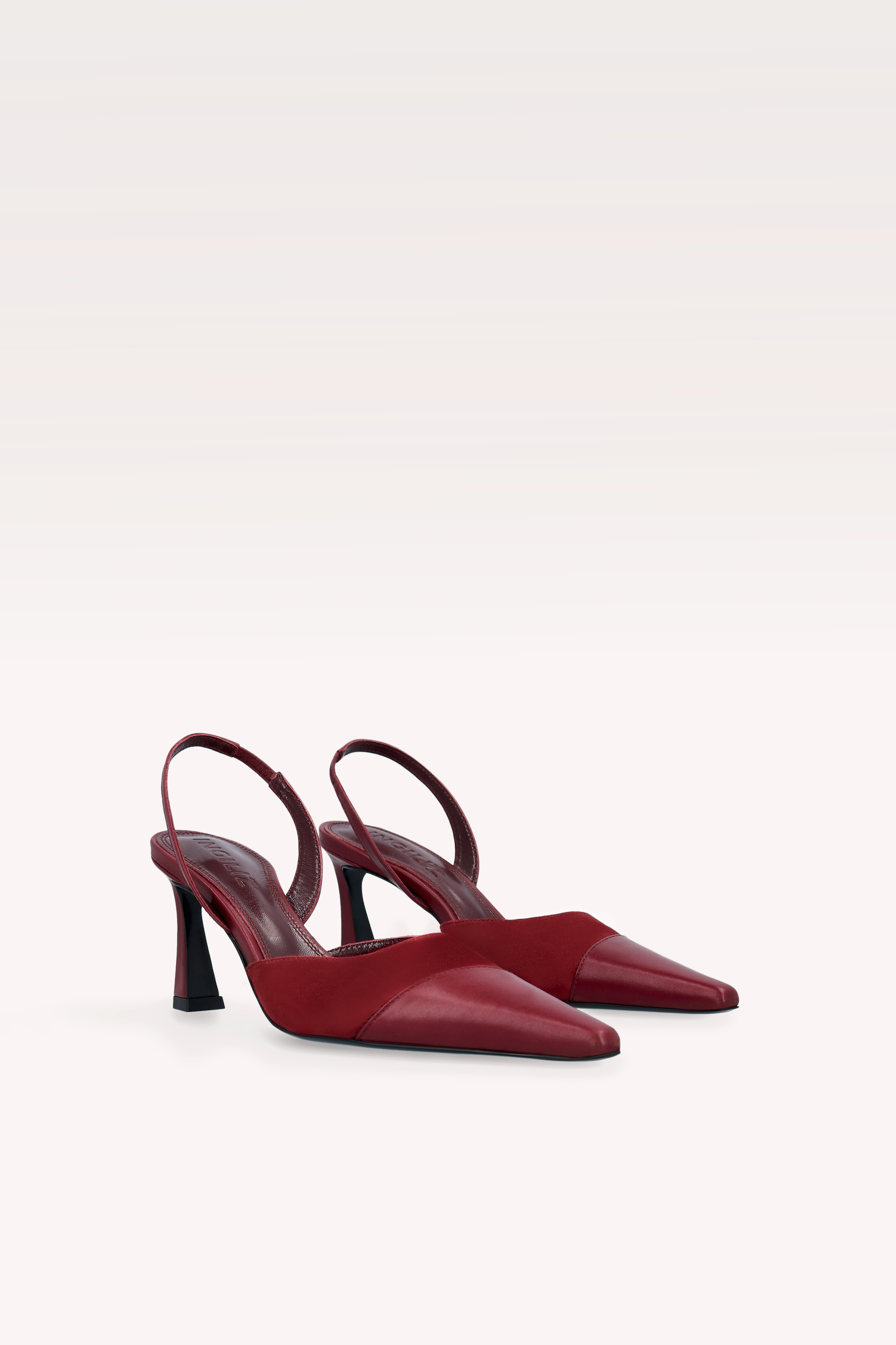 Pair of red high-heeled shoes on a white background